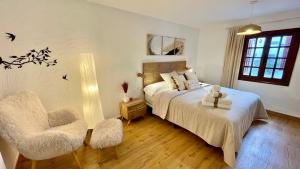 ein Schlafzimmer mit einem Bett und einem Stuhl sowie einem Bett sidx sidx sidx in der Unterkunft Troi Landetxea, Casa Rural Con encanto en el Goierri, Gipuzkoa, País Vasco in Mutiloa