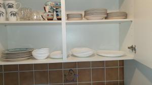 un armadio pieno di piatti, ciotole e piatti di Ctiy Home Peine a Peine Altre 2 foto