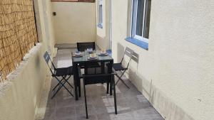 a small table and chairs on a balcony at Maison Proche Mer in Pia