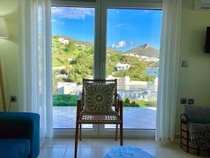 a chair sitting in front of a large window at The Blue House in Vromolithos