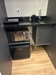 a kitchen with a sink and a microwave at Paraíso na mata in Cotia