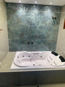 a bath tub in a bathroom with a shower at Paraíso na mata in Cotia