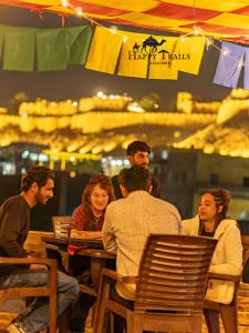 a group of people sitting at a table in a restaurant at Happy Trails Jaisalmer in Jaisalmer