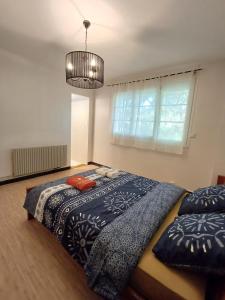 una camera da letto con un letto con un piumone blu e una finestra di l'auberge agenaise, 8pers , wifi , parking a Agen Altre 23 foto