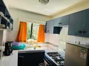 a kitchen with blue cabinets and a stove and a sink at Kiana homes lantana in Nairobi +19 photos