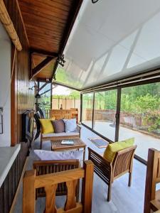 DraillantMaison entre lac et montagnes的一个带椅子和沙发的门廊