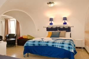a bedroom with a bed with blue lamps and a couch at Antico Monastero Di Anacapri in Anacapri