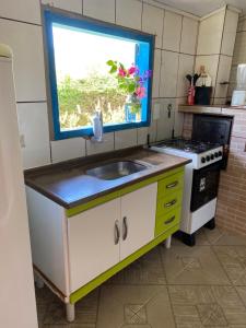 a kitchen with a sink and a window at Casa na Montanha a 500 metros da Pedra do Baú in São Bento do Sapucaí