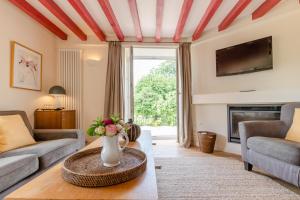 a living room with a vase of flowers on a table at Villa Louise in Aloxe-Corton