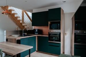 a kitchen with blue cabinets and a wooden table at Le Chat Léon in Chalon-sur-Saône