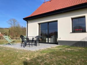 eine Terrasse mit Tisch und Stühlen vor einem Haus in der Unterkunft Les Petites Maisons dans la Prairie - 2 in Maresville + 2 Fotos