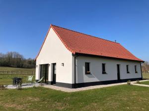 ein kleines weißes Haus mit einem roten Dach in der Unterkunft Les Petites Maisons dans la Prairie - 2 in Maresville