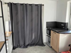 a grey curtain in a kitchen with a stove at Location Spay Proche circuit in Spay