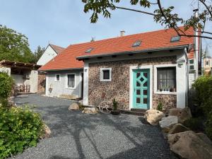 a house with a red roof and a blue door at Living Past Vendégház in Kővágóörs