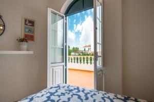 a bedroom with an open door to a balcony at HAUS NUNES by Stay in Alentejo in Vila Nova de Milfontes