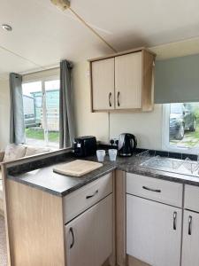 a kitchen with wooden cabinets and a counter top at MoonStone in Aberystwyth