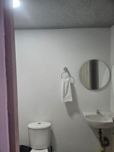 a bathroom with a white toilet and a sink at La Estrella in Dosquebradas +5 photos