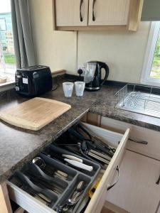 a kitchen counter with an open drawer with knives at MoonStone in Aberystwyth