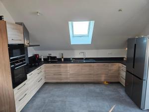 a kitchen with wooden cabinets and a sink and a window at Logement proche Bourboule 12 personnes in Massanges