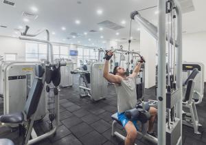 a man is in the gym performing a bar workout at 33th Floor - SkyView Oasis - A in Skopje