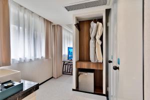 a room with a closet with white clothes in it at Yurong West Lake Cottage Resort Hotel Hangzhou in Hangzhou