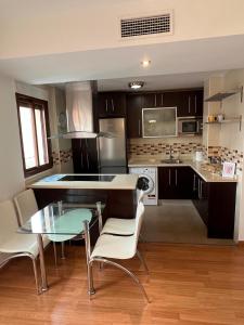 a kitchen with a glass table and chairs in it at Apartamento para turismo en Granada in Peligros