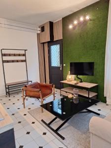a living room with a couch and a tv at La maison du bout d en haut in Bessancourt