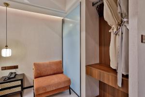 a small room with a chair and a window at Yurong West Lake Cottage Resort Hotel Hangzhou in Hangzhou