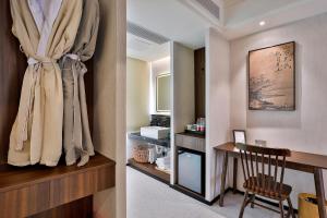 a hotel room with a desk and a curtain at Yurong West Lake Cottage Resort Hotel Hangzhou in Hangzhou