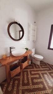 a bathroom with a sink and a toilet and a mirror at Casa La Morera, Ávila in Avila +18 photos