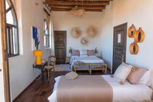 a bedroom with two beds in a room at Maison la chèvre By Nath & Lulu in Essaouira +74 photos