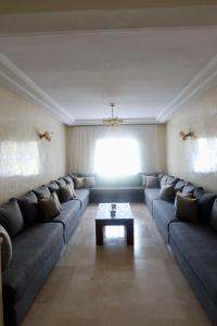 a living room with a blue couch and a coffee table at Luxury 3 Bedroom apartment Iberia in Tangier