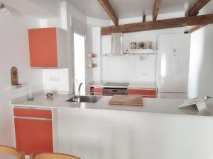 a kitchen with red and white cabinets and a sink at Casa Bonaire Dénia in Denia