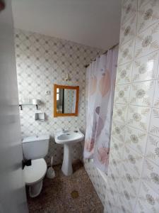 a bathroom with a white toilet and a sink at Hostal San Miguel in Villalobar