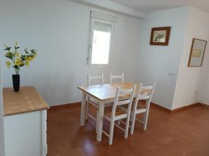 a table and chairs in a kitchen with a window at Apartamento frente al mar in Les Cases d'Alcanar