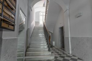 a staircase in a building with a checkered floor at Pico Apartments - Roma 20 in Sanremo +20 photos