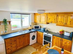 a kitchen with wooden cabinets and a sink and a dishwasher at The Star Inn in Dingle