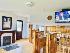 a living room with a fireplace and a flat screen tv at The Star Inn in Dingle