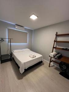 a small bedroom with a bed and a ladder at Apartamento semi-Novo Litoral Itajaí Sc in Itajaí