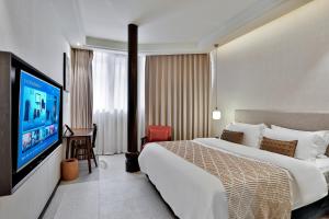 a hotel room with a bed and a flat screen tv at Yurong West Lake Cottage Resort Hotel Hangzhou in Hangzhou