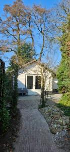 a white house with a bench in front of it at Veluws Huisje in Apeldoorn
