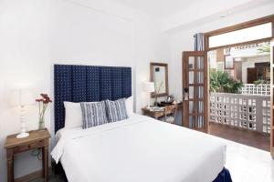 Postel nebo postele na pokoji v ubytování Adhisthana Hotel Yogyakarta