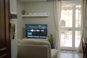 カスティリオーネ・デッラ・ペスカーイアにあるUn passo dal Mare - 50m from the Sea, with Garden, AC & WiFiの薄型テレビとソファのあるリビングルーム