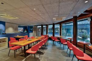 a restaurant with wooden tables and red chairs at Yurong West Lake Cottage Resort Hotel Hangzhou in Hangzhou