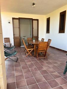 een patio met een houten tafel en stoelen bij Villa Capri Holiday Home in Campofelice di Roccella