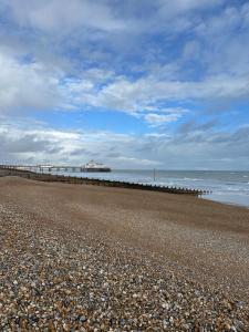 ein felsiger Strand mit einem Pier im Meer in der Unterkunft Home By The Sea in Eastbourne + 18 Fotos