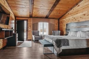 a bedroom with a bed and two chairs and a television at The View Boutique Hotel Suites in Tully