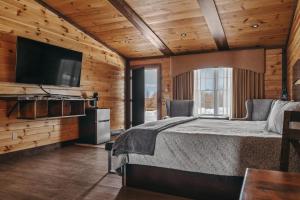 a bedroom with a bed and a flat screen tv at The View Boutique Hotel Suites in Tully