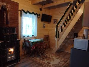 a living room with a table and a stove at Cabana Ulmului in Vişeu de Sus