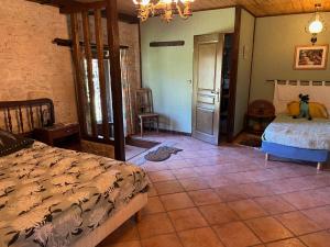 a bedroom with a bed and a tiled floor at La Tour du Sorbey - Gîte Nature Familial - Piscine - 3 à 6 Pax in Monségur